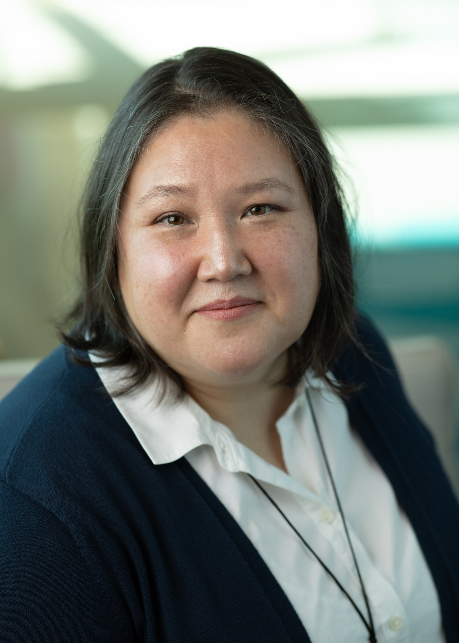 Kim Samayoa, woman with dark hair, wearing blue sweater and white top