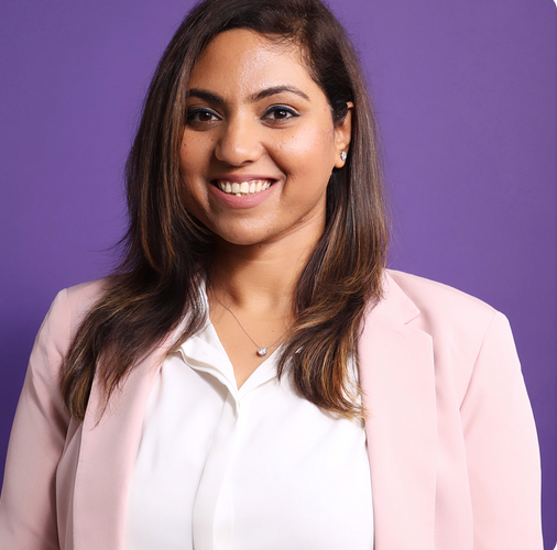 Shagun Tewari, smiling woman wearing a white blouse with pink jacket, with long brown hair